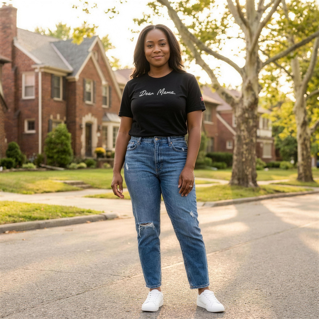 Black woman wearing the Retro Black Dear Mama tee on a tree lined Detroit street