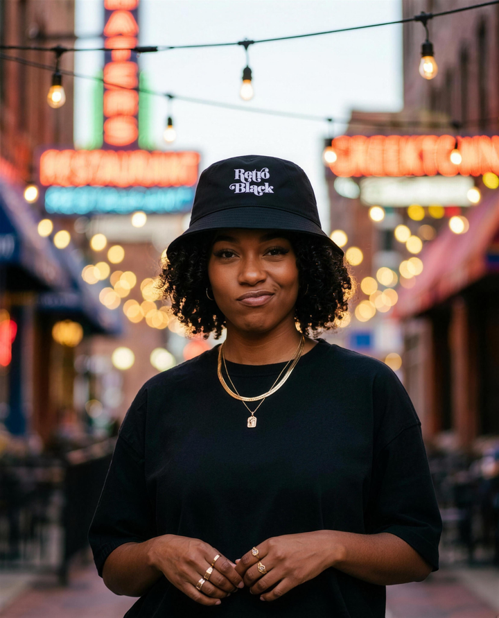 Black woman wearing the Retro Black bucket hat under string lights in Greektown Detroit