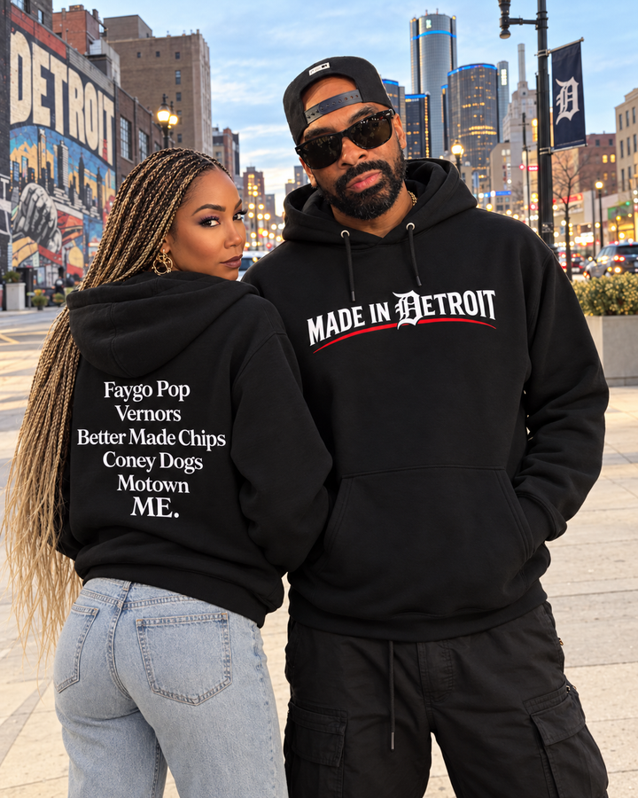 Will and Leah in downtown Detroit wearing black Made in Detroit hoodies, showing front and back graphics